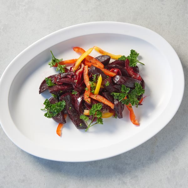 Altu's Ethiopian Cuisine's colorful beet salad with bell peppers and parsley on a white oval plate.