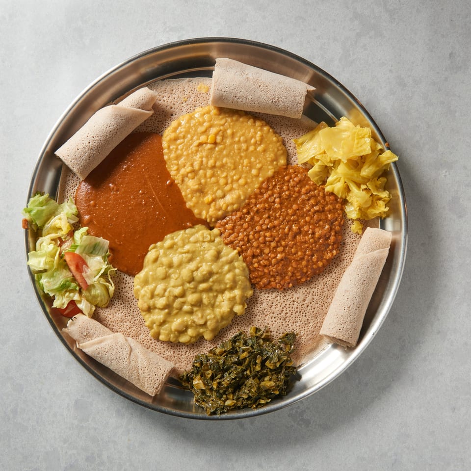 Altu's Ethiopian Cuisine platter with injera, various lentil stews, cabbage, and greens.